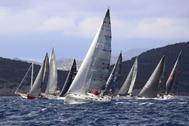 Bodrum, Hindi. 11 Ocak 2025: Yelkenliler Ege Denizi 'nin mavi sularında, ünlü tatil beldesi Bodrum' un kıyılarında rüzgarlı havada yelken açıyorlar..