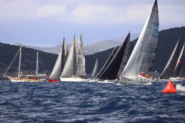 Bodrum, Hindi. 11 Ocak 2025: Yelkenliler Ege Denizi 'nin mavi sularında, ünlü tatil beldesi Bodrum' un kıyılarında rüzgarlı havada yelken açıyorlar..