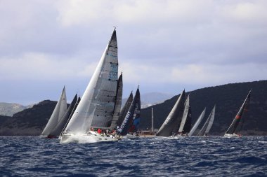 Bodrum, Hindi. 11 Ocak 2025: Yelkenliler Ege Denizi 'nin mavi sularında, ünlü tatil beldesi Bodrum' un kıyılarında rüzgarlı havada yelken açıyorlar..