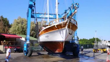 Bodrum, Mugla, Türkiye. 25 Eylül 2024: Tur teknesi bakım için kıyıya getirildi. Vinç tekneyi kıyıya taşıyor..