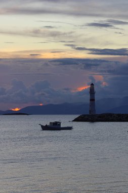 Gün ışığında deniz manzarası. Deniz feneri ve sahilde yelkenliler. Deniz kenti Turgutreis ve muhteşem güneş ışığı