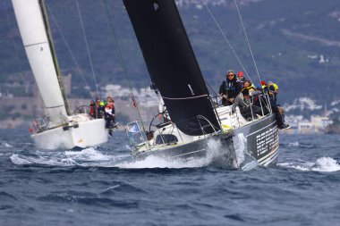 Bodrum, Hindi. 12 Ocak 2025: Yelkenliler Ege Denizi 'nin mavi sularında, ünlü tatil beldesi Bodrum' un kıyılarında rüzgarlı havada yelken açıyorlar..