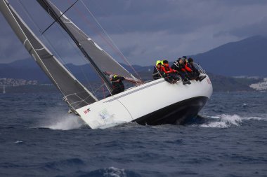 Bodrum, Hindi. 12 Ocak 2025: Yelkenliler Ege Denizi 'nin mavi sularında, ünlü tatil beldesi Bodrum' un kıyılarında rüzgarlı havada yelken açıyorlar..