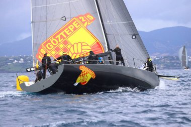 Bodrum, Hindi. 12 Ocak 2025: Yelkenliler Ege Denizi 'nin mavi sularında, ünlü tatil beldesi Bodrum' un kıyılarında rüzgarlı havada yelken açıyorlar..