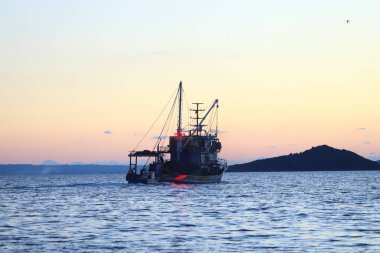 Bodrum, Mugla, Türkiye. 28 Ocak 2025: Denizdeki tekne. Akşamları yelken açan bir balıkçı teknesi...