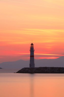 Gün ışığında deniz manzarası. Deniz feneri ve sahilde yelkenliler. Deniz kenti Turgutreis ve muhteşem güneş ışığı