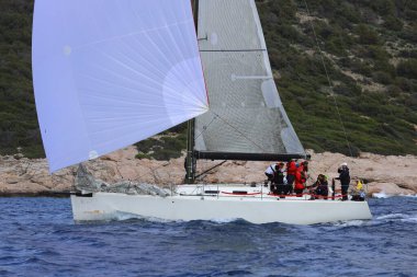 Bodrum, Hindi. 12 Ocak 2025: Yelkenliler Ege Denizi 'nin mavi sularında, ünlü tatil beldesi Bodrum' un kıyılarında rüzgarlı havada yelken açıyorlar..