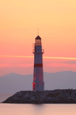 Gün ışığında deniz manzarası. Deniz feneri ve sahilde yelkenliler. Deniz kenti Turgutreis ve muhteşem güneş ışığı