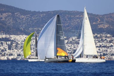 Bodrum, Hindi. 02 Şubat 2025: Ege Denizi 'nin mavi sularında, ünlü tatil beldesi Bodrum' un kıyılarında yelkenliler rüzgarlı havada yelken açıyor.