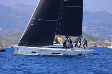 Bodrum, Hindi. 08 Mart 2025: Yelkenliler Ege Denizi 'nin mavi sularında, ünlü tatil beldesi Bodrum' un kıyılarında rüzgarlı havada yelken açıyorlar..
