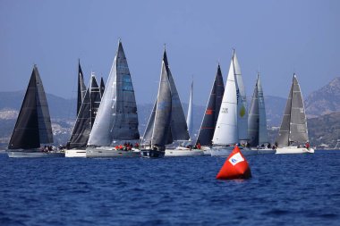 Bodrum, Hindi. 08 Mart 2025: Yelkenliler Ege Denizi 'nin mavi sularında, ünlü tatil beldesi Bodrum' un kıyılarında rüzgarlı havada yelken açıyorlar..