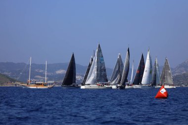 Bodrum, Hindi. 08 Mart 2025: Yelkenliler Ege Denizi 'nin mavi sularında, ünlü tatil beldesi Bodrum' un kıyılarında rüzgarlı havada yelken açıyorlar..
