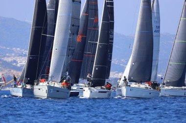 Bodrum, Hindi. 08 Mart 2025: Yelkenliler Ege Denizi 'nin mavi sularında, ünlü tatil beldesi Bodrum' un kıyılarında rüzgarlı havada yelken açıyorlar..