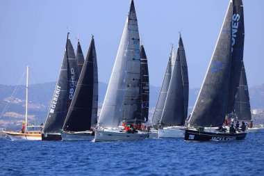Bodrum, Hindi. 08 Mart 2025: Yelkenliler Ege Denizi 'nin mavi sularında, ünlü tatil beldesi Bodrum' un kıyılarında rüzgarlı havada yelken açıyorlar..