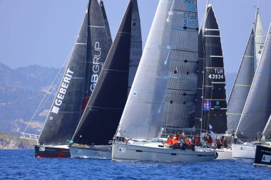 Bodrum, Hindi. 08 Mart 2025: Yelkenliler Ege Denizi 'nin mavi sularında, ünlü tatil beldesi Bodrum' un kıyılarında rüzgarlı havada yelken açıyorlar..