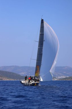 Bodrum, Hindi. 08 Mart 2025: Yelkenliler Ege Denizi 'nin mavi sularında, ünlü tatil beldesi Bodrum' un kıyılarında rüzgarlı havada yelken açıyorlar..