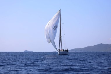 Bodrum, Hindi. 08 Mart 2025: Yelkenliler Ege Denizi 'nin mavi sularında, ünlü tatil beldesi Bodrum' un kıyılarında rüzgarlı havada yelken açıyorlar..