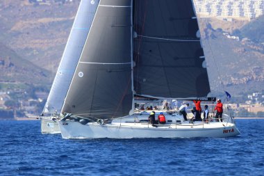 Bodrum, Hindi. 08 Mart 2025: Yelkenliler Ege Denizi 'nin mavi sularında, ünlü tatil beldesi Bodrum' un kıyılarında rüzgarlı havada yelken açıyorlar..
