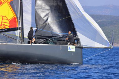 Bodrum, Hindi. 08 Mart 2025: Yelkenliler Ege Denizi 'nin mavi sularında, ünlü tatil beldesi Bodrum' un kıyılarında rüzgarlı havada yelken açıyorlar..