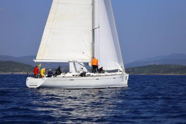 Bodrum, Hindi. 08 Mart 2025: Yelkenliler Ege Denizi 'nin mavi sularında, ünlü tatil beldesi Bodrum' un kıyılarında rüzgarlı havada yelken açıyorlar..