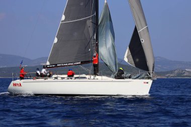 Bodrum, Hindi. 08 Mart 2025: Yelkenliler Ege Denizi 'nin mavi sularında, ünlü tatil beldesi Bodrum' un kıyılarında rüzgarlı havada yelken açıyorlar..