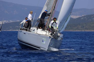 Bodrum, Hindi. 08 Mart 2025: Yelkenliler Ege Denizi 'nin mavi sularında, ünlü tatil beldesi Bodrum' un kıyılarında rüzgarlı havada yelken açıyorlar..