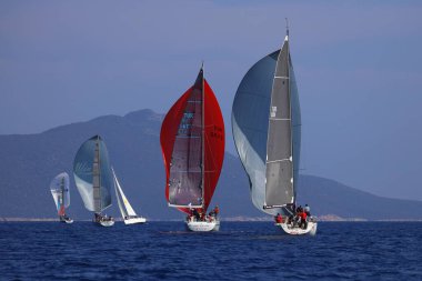 Bodrum, Hindi. 08 Mart 2025: Yelkenliler Ege Denizi 'nin mavi sularında, ünlü tatil beldesi Bodrum' un kıyılarında rüzgarlı havada yelken açıyorlar..
