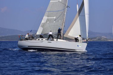 Bodrum, Hindi. 08 Mart 2025: Yelkenliler Ege Denizi 'nin mavi sularında, ünlü tatil beldesi Bodrum' un kıyılarında rüzgarlı havada yelken açıyorlar..