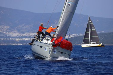 Bodrum, Hindi. 08 Mart 2025: Yelkenliler Ege Denizi 'nin mavi sularında, ünlü tatil beldesi Bodrum' un kıyılarında rüzgarlı havada yelken açıyorlar..