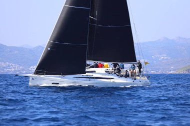 Bodrum, Hindi. 08 Mart 2025: Yelkenliler Ege Denizi 'nin mavi sularında, ünlü tatil beldesi Bodrum' un kıyılarında rüzgarlı havada yelken açıyorlar..