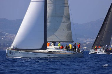 Bodrum, Hindi. 08 Mart 2025: Yelkenliler Ege Denizi 'nin mavi sularında, ünlü tatil beldesi Bodrum' un kıyılarında rüzgarlı havada yelken açıyorlar..