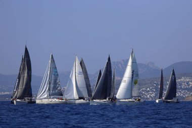 Bodrum, Hindi. 08 Mart 2025: Yelkenliler Ege Denizi 'nin mavi sularında, ünlü tatil beldesi Bodrum' un kıyılarında rüzgarlı havada yelken açıyorlar..