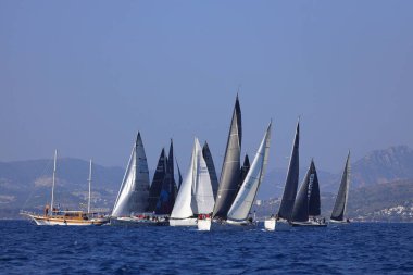 Bodrum, Hindi. 08 Mart 2025: Yelkenliler Ege Denizi 'nin mavi sularında, ünlü tatil beldesi Bodrum' un kıyılarında rüzgarlı havada yelken açıyorlar..