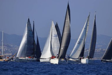 Bodrum, Hindi. 08 Mart 2025: Yelkenliler Ege Denizi 'nin mavi sularında, ünlü tatil beldesi Bodrum' un kıyılarında rüzgarlı havada yelken açıyorlar..