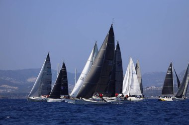 Bodrum, Hindi. 08 Mart 2025: Yelkenliler Ege Denizi 'nin mavi sularında, ünlü tatil beldesi Bodrum' un kıyılarında rüzgarlı havada yelken açıyorlar..