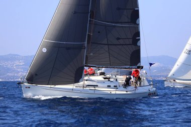 Bodrum, Hindi. 08 Mart 2025: Yelkenliler Ege Denizi 'nin mavi sularında, ünlü tatil beldesi Bodrum' un kıyılarında rüzgarlı havada yelken açıyorlar..