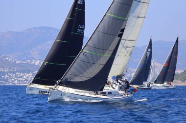 Bodrum, Hindi. 08 Mart 2025: Yelkenliler Ege Denizi 'nin mavi sularında, ünlü tatil beldesi Bodrum' un kıyılarında rüzgarlı havada yelken açıyorlar..