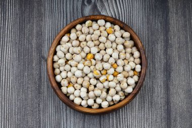 Ahşap arka planda ahşap kasede kavrulmuş beyaz nohut, üst manzara. Beyaz bezelyeler, yüksek lif içerikleriyle, tüketmek için çok sağlıklıdırlar..