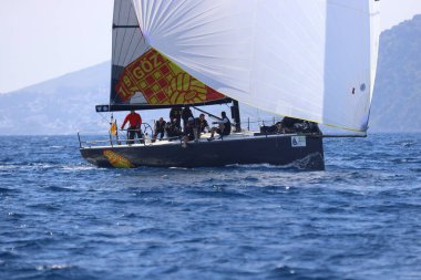 Bodrum, Hindi. 08 Mart 2025: Yelkenliler Ege Denizi 'nin mavi sularında, ünlü tatil beldesi Bodrum' un kıyılarında rüzgarlı havada yelken açıyorlar..