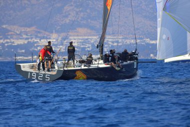 Bodrum, Hindi. 08 Mart 2025: Yelkenliler Ege Denizi 'nin mavi sularında, ünlü tatil beldesi Bodrum' un kıyılarında rüzgarlı havada yelken açıyorlar..