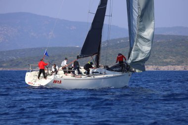 Bodrum, Hindi. 08 Mart 2025: Yelkenliler Ege Denizi 'nin mavi sularında, ünlü tatil beldesi Bodrum' un kıyılarında rüzgarlı havada yelken açıyorlar..