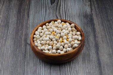 Ahşap arka planda ahşap kasede kavrulmuş beyaz nohut, üst manzara. Beyaz bezelyeler, yüksek lif içerikleriyle, tüketmek için çok sağlıklıdırlar..