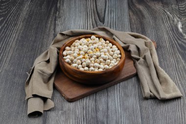 Ahşap arka planda ahşap kasede kavrulmuş beyaz nohut, üst manzara. Beyaz bezelyeler, yüksek lif içerikleriyle, tüketmek için çok sağlıklıdırlar..