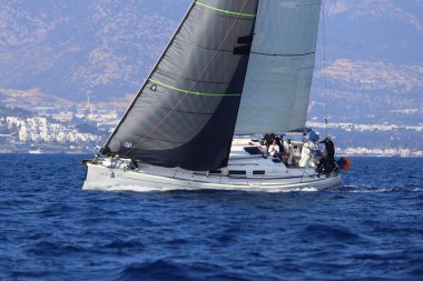Bodrum, Hindi. 08 Mart 2025: Yelkenliler Ege Denizi 'nin mavi sularında, ünlü tatil beldesi Bodrum' un kıyılarında rüzgarlı havada yelken açıyorlar..