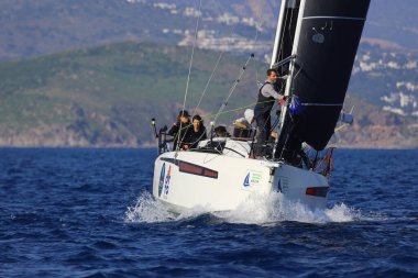 Bodrum, Hindi. 08 Mart 2025: Yelkenliler Ege Denizi 'nin mavi sularında, ünlü tatil beldesi Bodrum' un kıyılarında rüzgarlı havada yelken açıyorlar..