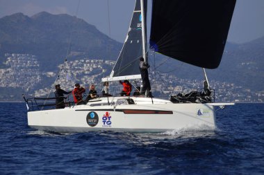 Bodrum, Hindi. 08 Mart 2025: Yelkenliler Ege Denizi 'nin mavi sularında, ünlü tatil beldesi Bodrum' un kıyılarında rüzgarlı havada yelken açıyorlar..