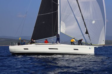 Bodrum, Hindi. 08 Mart 2025: Yelkenliler Ege Denizi 'nin mavi sularında, ünlü tatil beldesi Bodrum' un kıyılarında rüzgarlı havada yelken açıyorlar..