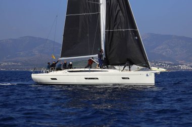 Bodrum, Hindi. 08 Mart 2025: Yelkenliler Ege Denizi 'nin mavi sularında, ünlü tatil beldesi Bodrum' un kıyılarında rüzgarlı havada yelken açıyorlar..