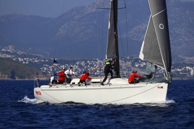 Bodrum, Hindi. 08 Mart 2025: Yelkenliler Ege Denizi 'nin mavi sularında, ünlü tatil beldesi Bodrum' un kıyılarında rüzgarlı havada yelken açıyorlar..