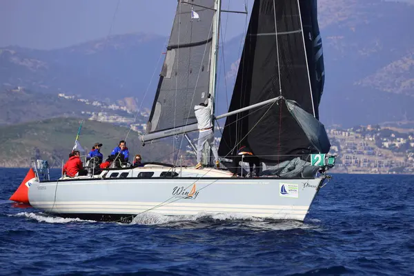 Bodrum, Hindi. 08 Mart 2025: Yelkenliler Ege Denizi 'nin mavi sularında, ünlü tatil beldesi Bodrum' un kıyılarında rüzgarlı havada yelken açıyorlar..